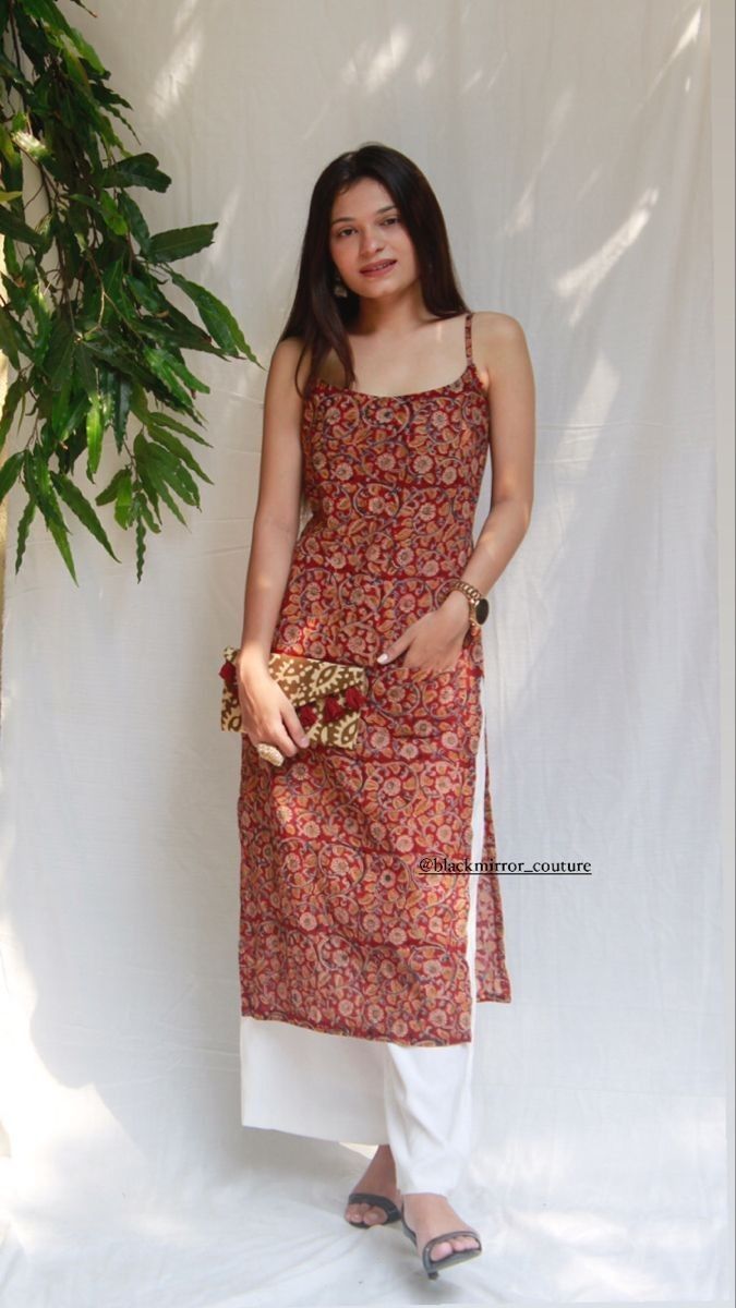 Model wearing a patterned kurti with white trousers.