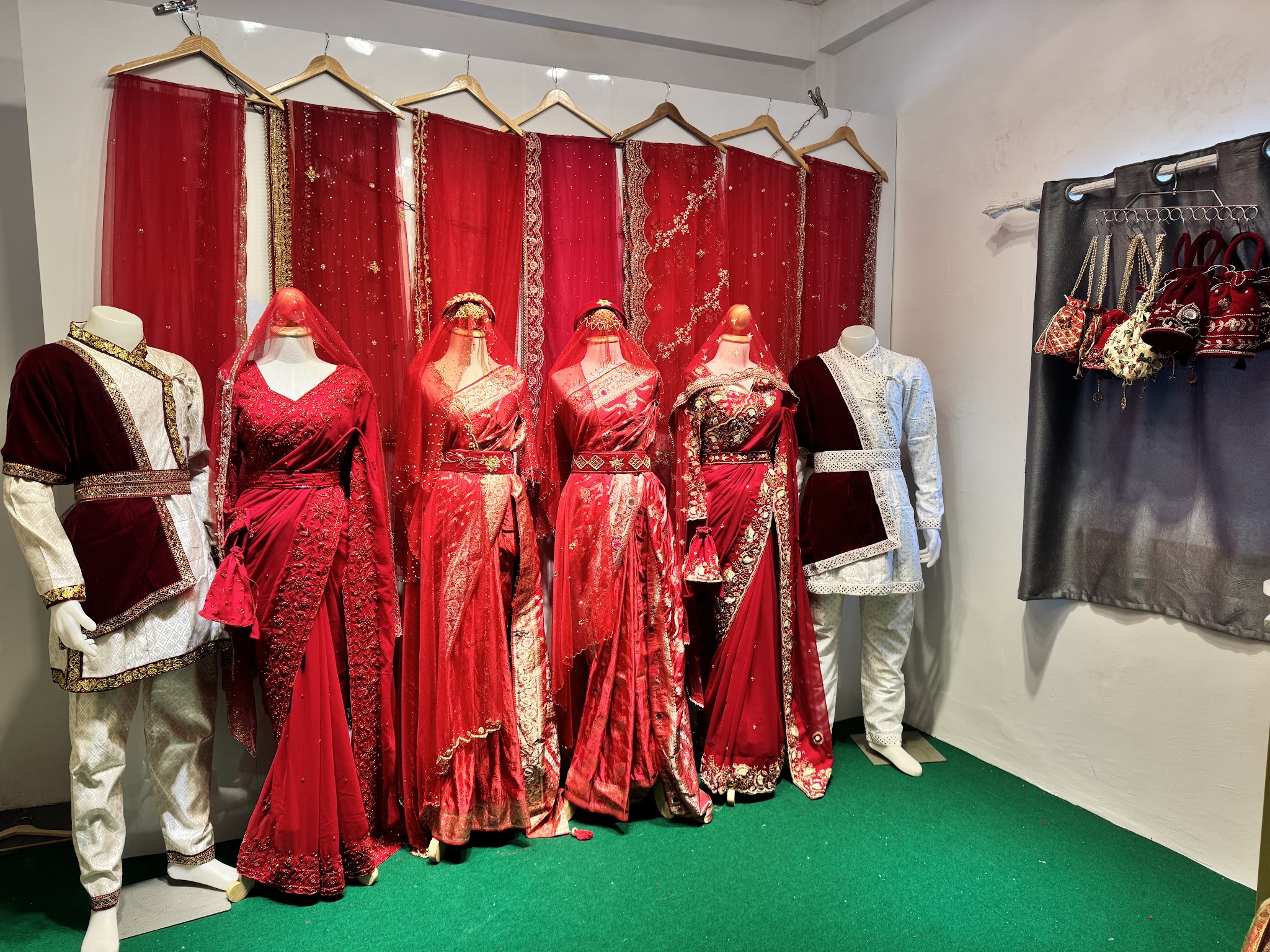 Mannequins wearing red traditional outfits in a clothing store.